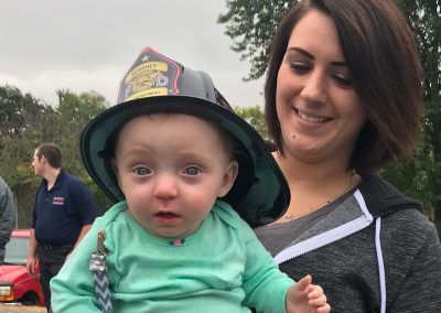 Teacher with infant wearing fireman's hat